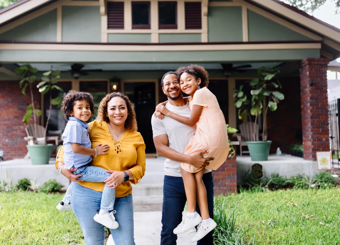 family with two kids in front of their house